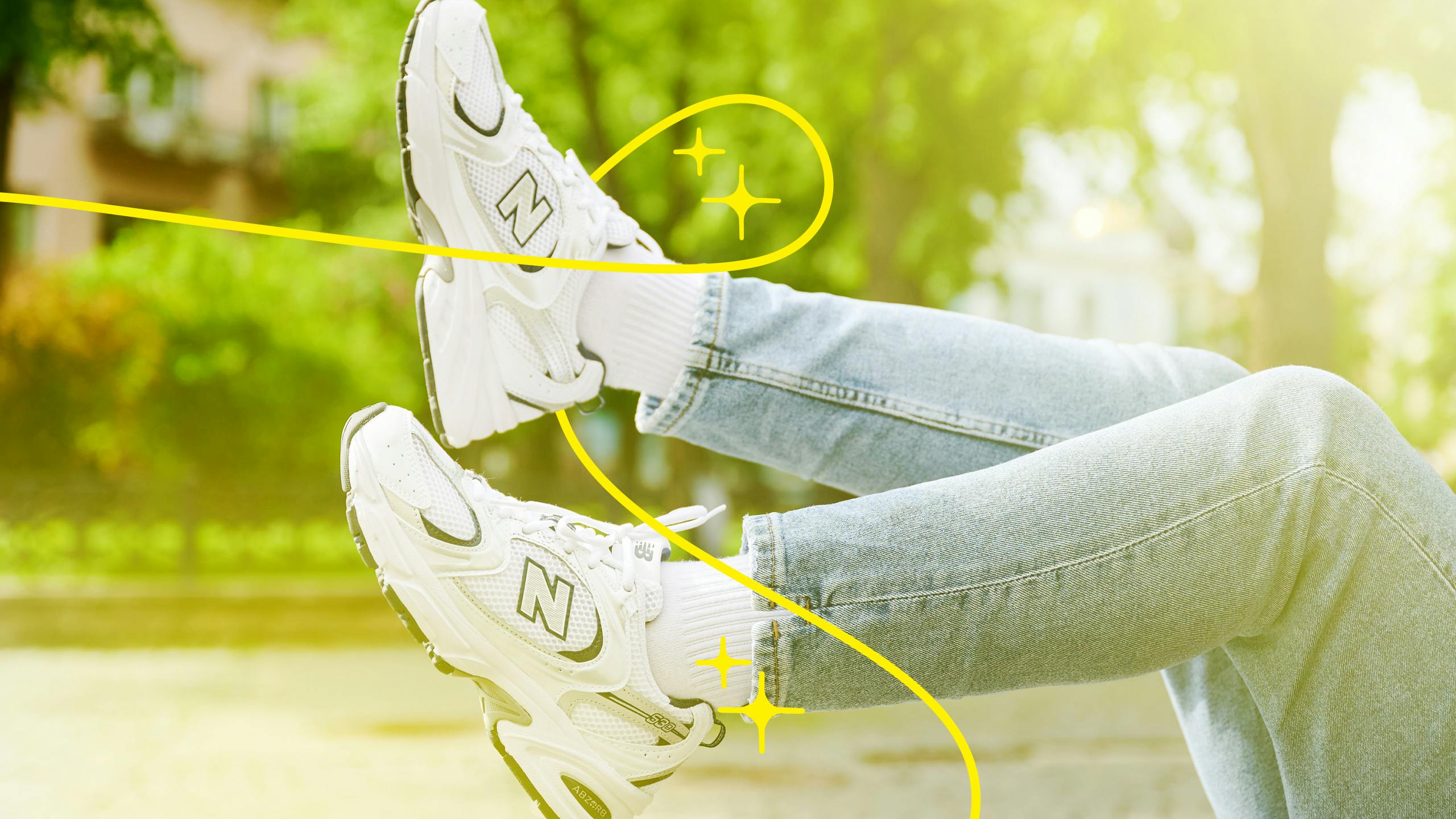 Someone lying on their back with their New Balance sneakers kicked up into the air. There is sparkles drawn on the image